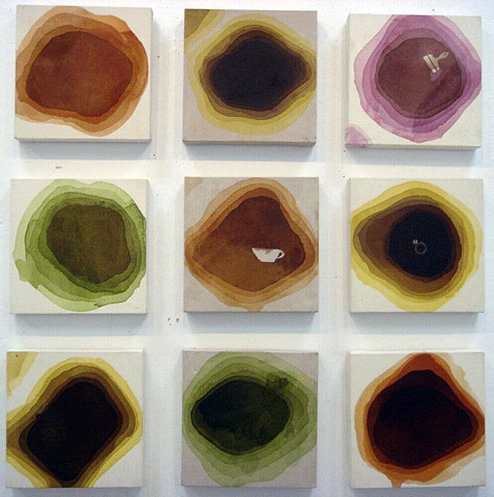 Daily Life — nine square panels in a three by three grid, each a concentric ring of colour in earth tones, some holding a small white object at the centre