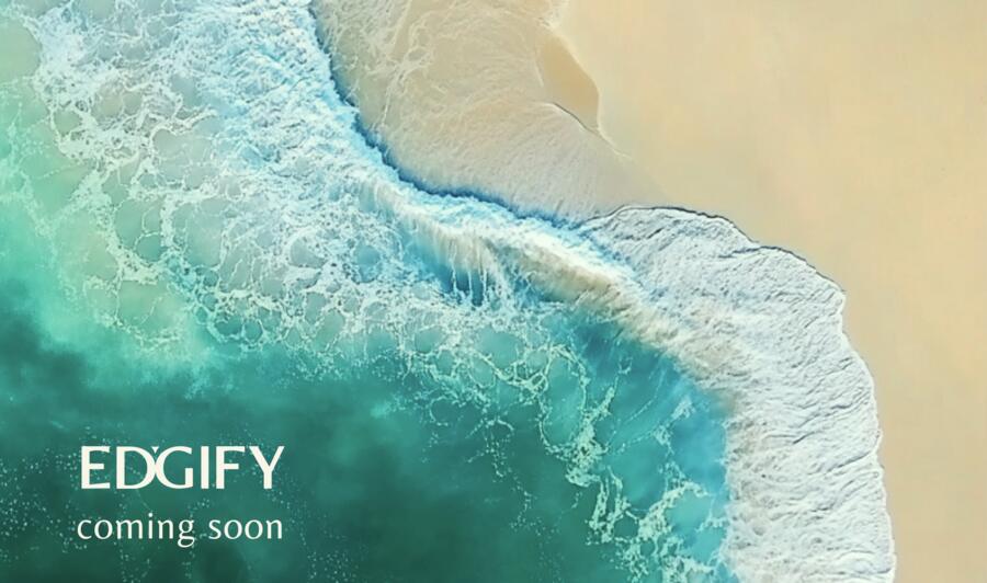 Identity study — an aerial view of turquoise surf breaking against pale sand, the wordmark set into the water