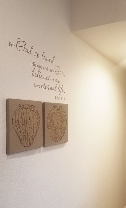 Installation view — two small textured panels, each with an incised vessel drawn in fine linear fragments, hung on a domestic wall